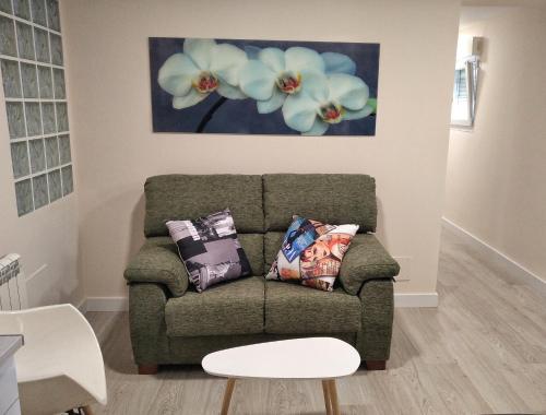 a couch in a living room with a painting on the wall at Apartamento en Avenida Quevedo in León