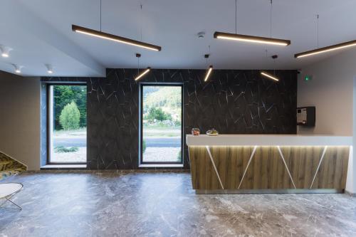 a lobby with a counter and two windows at Nedei Hotel&Spa Transalpina in Martinie