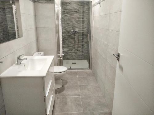 een badkamer met een wastafel, een toilet en een douche bij Apartamento en Avenida Quevedo in León