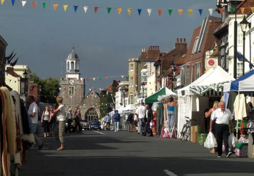 a group of people walking down a street with tents at THE HIDEAWAY - LUXURY SELF CATERING COASTAL APARTMENT with PRIVATE ENTRANCE & KEY BOX ENTRY JUST A FEW MINUTES WALK TO THE BEACH, SOLENT WAY WALK, SHOPS and many EATERIES & BARS - FREE OFF ROAD PARKING,FULL KITCHEN, LOUNGE,BEDROOM , BATHROOM & WI-FI in Lymington
