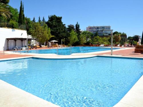 uma grande piscina com água azul em Apartment Armenka Duquesa em Torremolinos