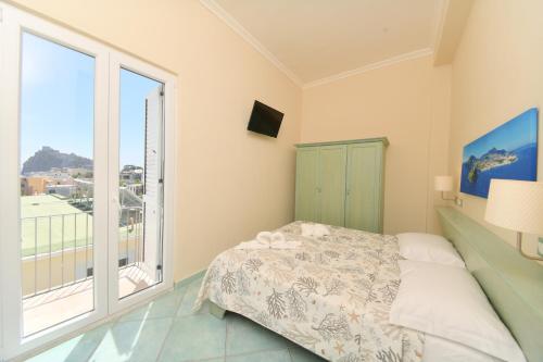 a bedroom with a bed and a large window at Albergo Atlantic in Ischia