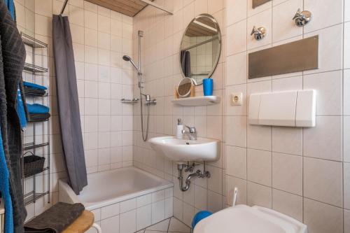 ein Badezimmer mit einem Waschbecken, einem WC und einem Spiegel in der Unterkunft Hof Wagenberg Ferienwohnung 1 in Deggenhausertal