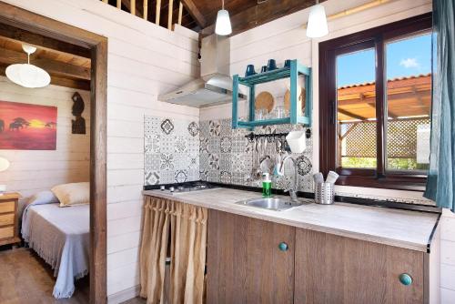 una cocina con fregadero y una cama en una habitación en El Viajero, en Roche