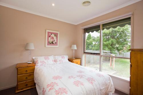 1 dormitorio con cama y ventana grande en Geelong Holiday Home, en Geelong