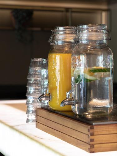 two glass jars of orange juice on a table at Hotel Restaurant Grandcafé 't Voorhuys in Emmeloord