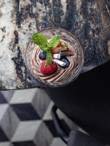 a dessert with a strawberry and blueberries on a table at Hotel Restaurant Grandcafé 't Voorhuys in Emmeloord