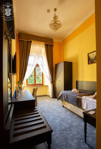 a hotel room with a bed and a desk and a window at Pałac Lubiechowa-Jelenia Góra- Riesengebirge in Lubiechowa