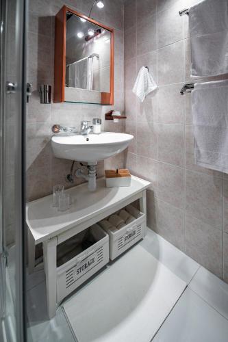 a bathroom with a sink and a mirror and a shower at Melina Heritage House in Cres