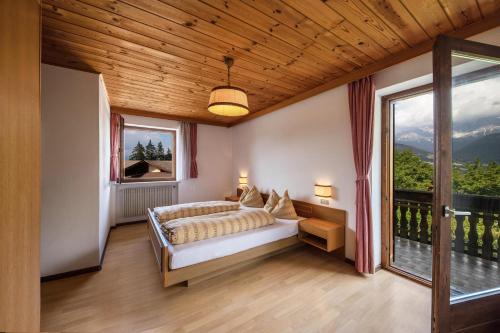a bedroom with a bed and a large window at Grödnerhof Heidi in Brie