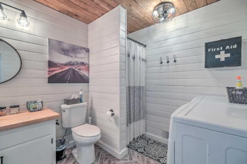 a white bathroom with a toilet and a sink at Chic and Modern Escape about 4 Mi to Pinecrest Lake! in Cold Springs
