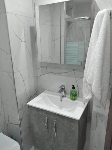 a white bathroom with a sink and a mirror at Hanioti View Apartment in Hanioti