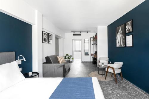 - une chambre avec un lit et un mur bleu dans l'établissement Play Theatrou Athens, à Athènes