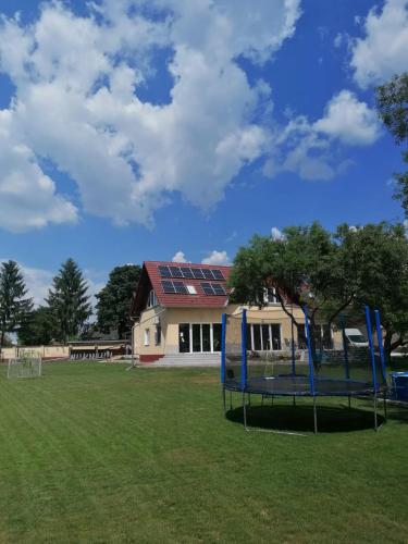 a park with a building in the background at Casa Napsugár Panzió in Apostag