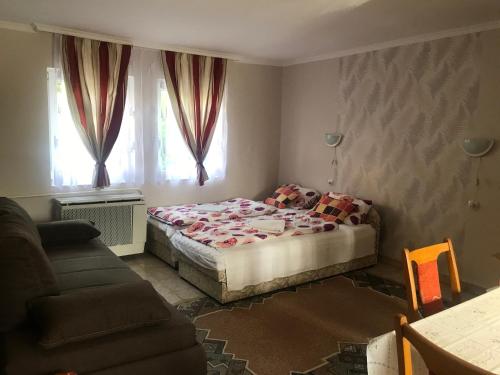 1 dormitorio pequeño con 1 cama y 1 sofá en Guest House Rózsakert, en Egerszalók