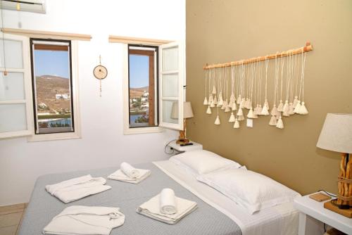 Habitación con 2 camas, toallas blancas y ventanas. en NEFELI SUITES KYTHNOS, en Loutra