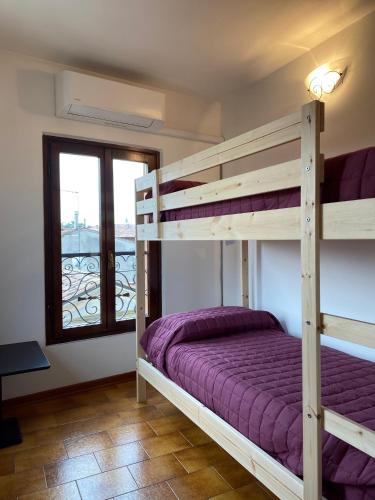 a bedroom with two bunk beds and a window at Anfite Apartments Aleardi in Peschiera del Garda