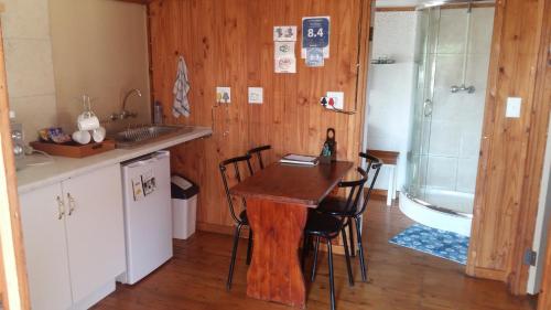 uma cozinha com mesa e cadeiras num quarto em The Cottage Polokwane em Polokwane