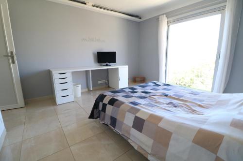 une chambre avec un lit et un bureau avec une télévision dans l'établissement Fantastic sea view for this 2 bedroom up to 6 people 327, à Cannes