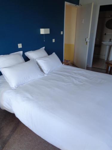 a large bed with white sheets and pillows at Auberge des genêts d'or in Ranchal