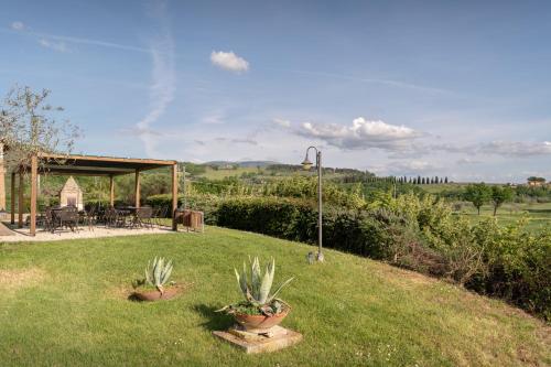 a garden with two potted plants in the grass at Residenza Il Falchetto in Assisi