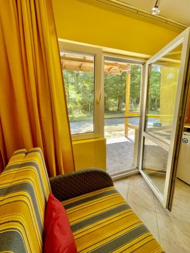 a yellow room with a couch and a window at Pop Аrt Bungalows in Primorsko