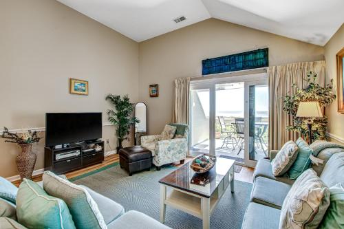 a living room with a couch and a tv at Pelican Watch 1380 in Seabrook Island