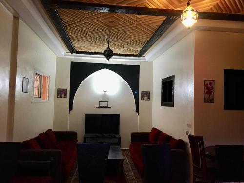 a living room with an arched window and a tv at Apart- Groupe Marhaba in Marrakesh