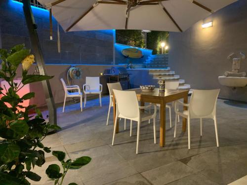 a dining room with a table and chairs and an umbrella at ISCA BLUE BEACH Casa in Villa vicino al mare, sino a max 8 persone in Isca sullo Ionio