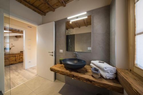 baño con lavabo de tazón negro en una encimera de madera en Corte Garibaldi, en Feltre