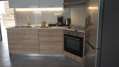 une cuisine avec un évier et une cuisinière four supérieur dans l'établissement Onar View Apartment, à Néa Péramos