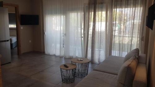 - un salon avec un canapé et deux tabourets dans l'établissement Onar View Apartment, à Néa Péramos