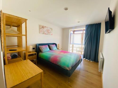 a bedroom with a bed with a colorful blanket at La Casona del Gallo in Ábalos
