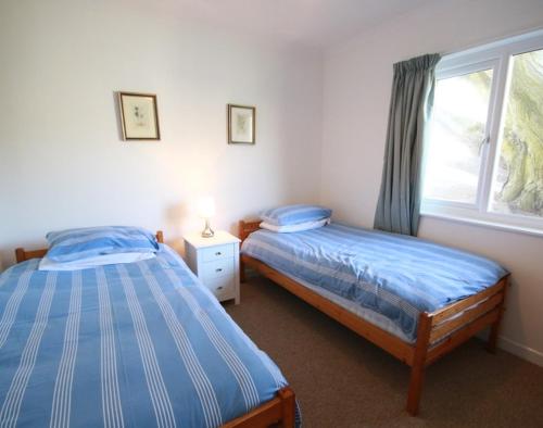 sypialnia z 2 łóżkami pojedynczymi i oknem w obiekcie Gullsway September Tide w mieście Polzeath