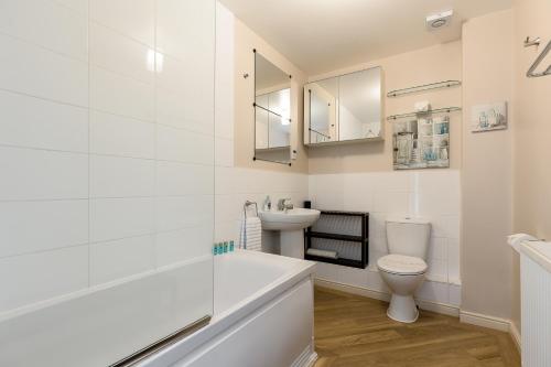 een witte badkamer met een toilet en een wastafel bij Bay Retreat in Poole