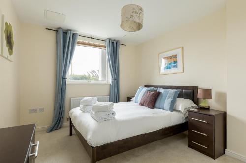 een slaapkamer met een bed met blauwe gordijnen en een raam bij Bay Retreat in Poole