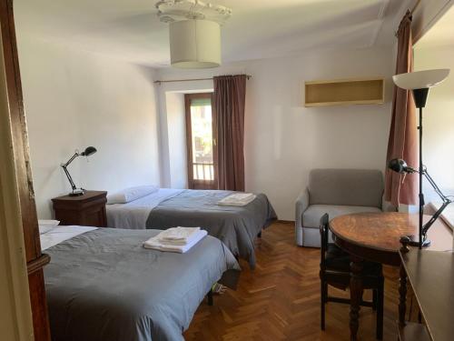 a room with two beds and a table and a couch at Dépendance 1816 in Morgex