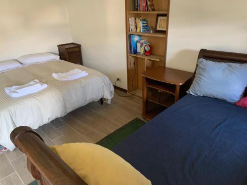 a room with two beds and a desk and a table at Dépendance 1816 in Morgex