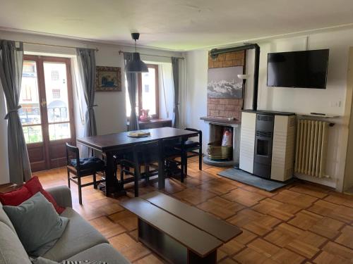a living room with a table and a couch at Dépendance 1816 in Morgex