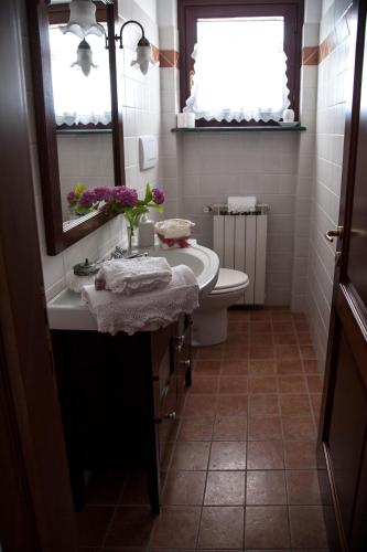 a bathroom with a sink and a toilet and a mirror at CASA VACANZA LA VILLA in Amelia