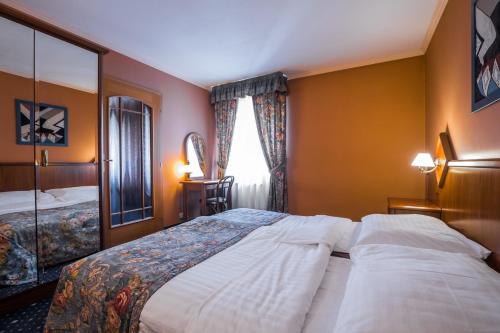 a hotel room with a bed and a window at Hotel Concertino Zlatá Husa in Jindrichuv Hradec