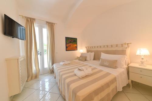 una camera da letto con un letto e asciugamani di Queen Suite - Luxury Rooms a Ischia