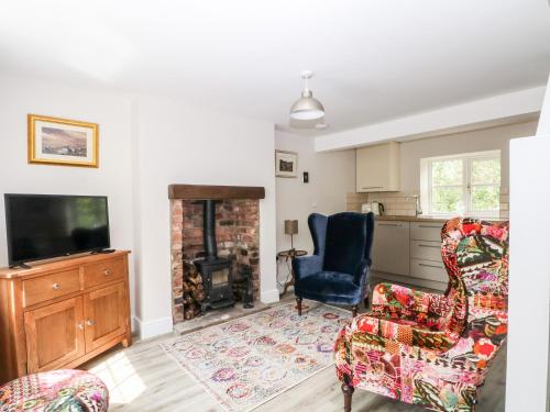 a living room with two chairs and a television at 3 Higher Lane in Macclesfield