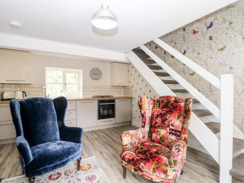 a living room with two chairs and a staircase at 3 Higher Lane in Macclesfield