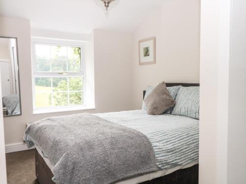 um quarto branco com uma cama e uma janela em 3 Higher Lane em Macclesfield