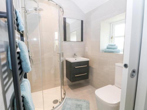 uma casa de banho com um chuveiro, um WC e um lavatório. em 3 Higher Lane em Macclesfield