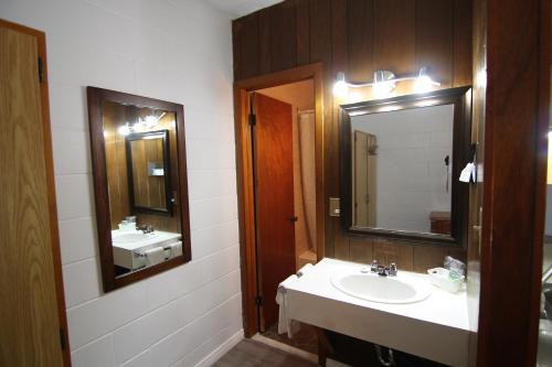 a bathroom with a sink and a mirror at Motel Lennoxville in Sherbrooke