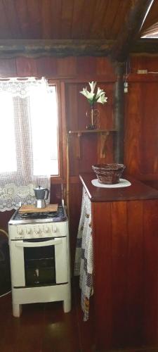 a kitchen with a white stove and a window at CASA DE CAMPO PATRIMÔNIO in Brotas