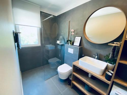 ein Badezimmer mit Waschbecken, Spiegel und Toilette in der Unterkunft Apartment Mouette in Poreč