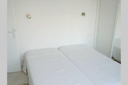 a white room with three white beds in it at F2 Climatisé Piscine Proche Plage in Cavalaire-sur-Mer